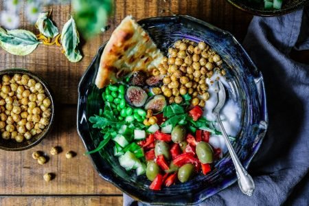 silver spoon on black ceramic bowl with vegetables