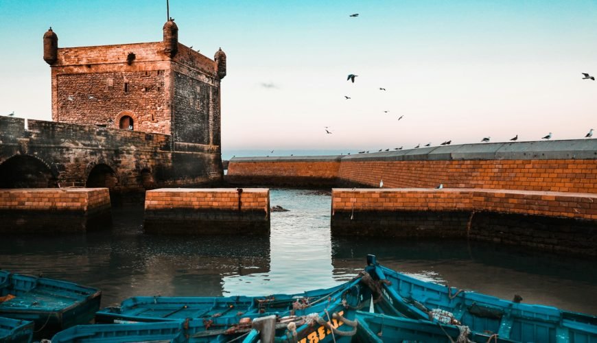 brown brick building near body of water during daytime