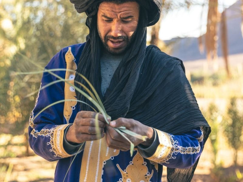 un hombre con un atuendo azul y negro sosteniendo un palo